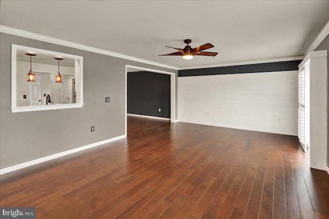 unfurnished living room with dark wood-style floors, ornamental molding, and a ceiling fan