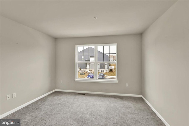 carpeted empty room with visible vents and baseboards