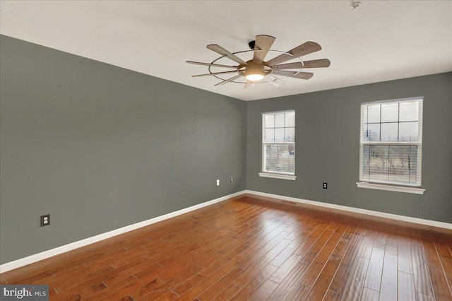 unfurnished room with ceiling fan, baseboards, and wood finished floors