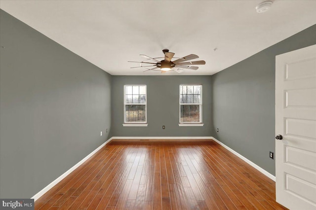 unfurnished room featuring a ceiling fan, baseboards, and wood finished floors