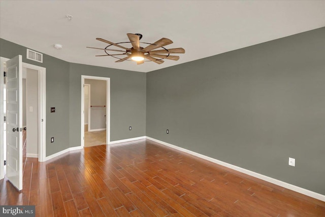 empty room with visible vents, ceiling fan, baseboards, and wood finished floors