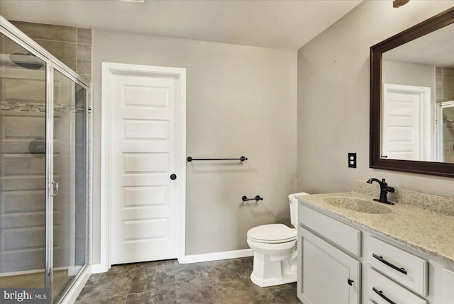 bathroom with toilet, a stall shower, baseboards, and vanity