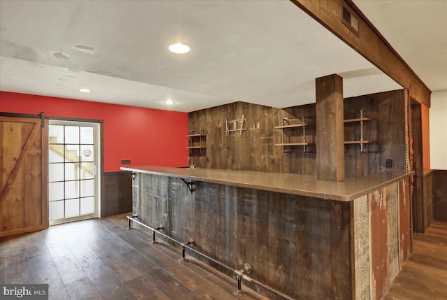 bar featuring a barn door, recessed lighting, visible vents, a dry bar, and dark wood finished floors