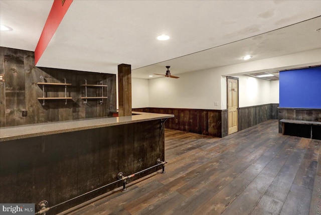 bar featuring dark wood-type flooring, recessed lighting, wainscoting, and a ceiling fan