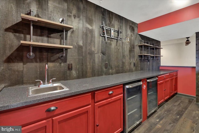 kitchen featuring dark countertops, beverage cooler, open shelves, and a sink