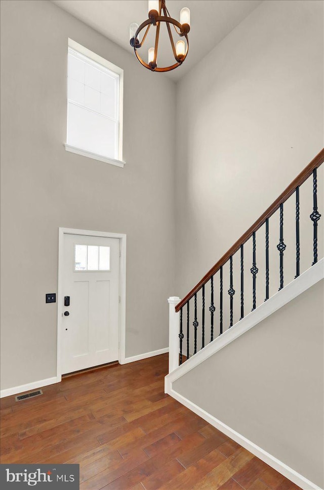 entrance foyer featuring stairway, wood finished floors, visible vents, and baseboards