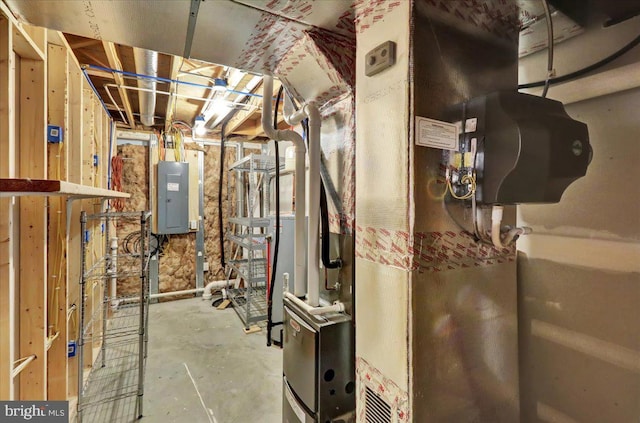 utility room featuring electric panel and heating unit