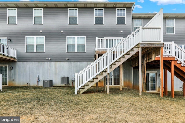 back of house with central AC, a yard, and stairway