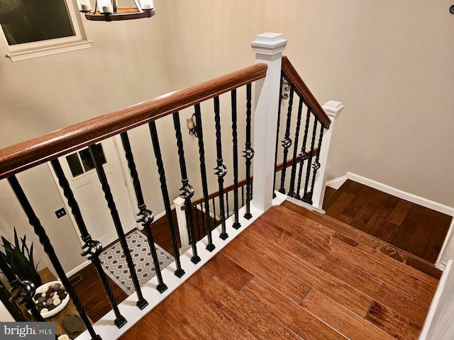 stairway featuring baseboards and wood finished floors