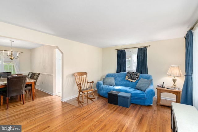 6510 Oakwood Dr, Falls Church, VA 22041 - living area with baseboards, an inviting chandelier, light wood-style flooring, and arched walkways