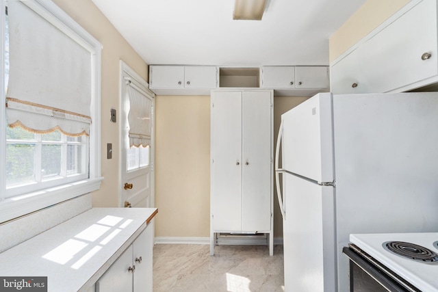 6510 Oakwood Dr, Falls Church, VA 22041 - kitchen with freestanding refrigerator, light countertops, baseboards, and white cabinets