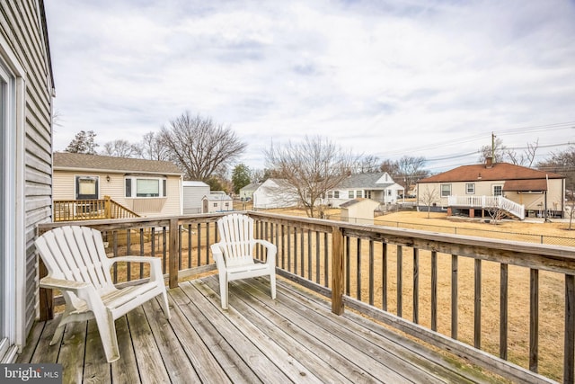 wooden deck featuring a lawn