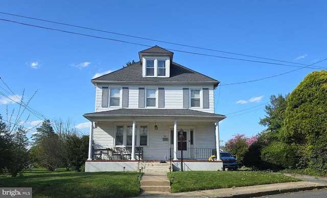 traditional style home featuring a porch and a front yard