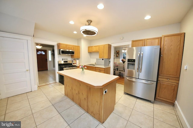 kitchen with light tile patterned floors, a center island, stainless steel appliances, light countertops, and recessed lighting