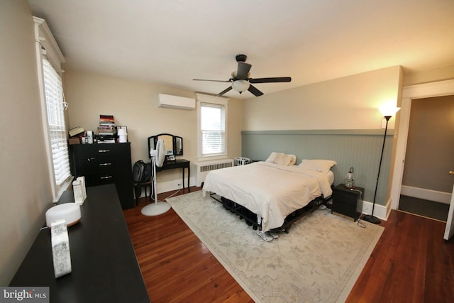 bedroom with dark wood-type flooring, a ceiling fan, baseboards, a wall mounted AC, and radiator