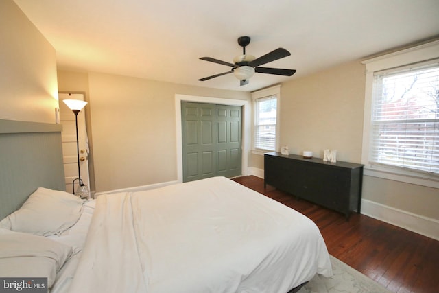 bedroom with a ceiling fan, dark wood-style flooring, a closet, and baseboards