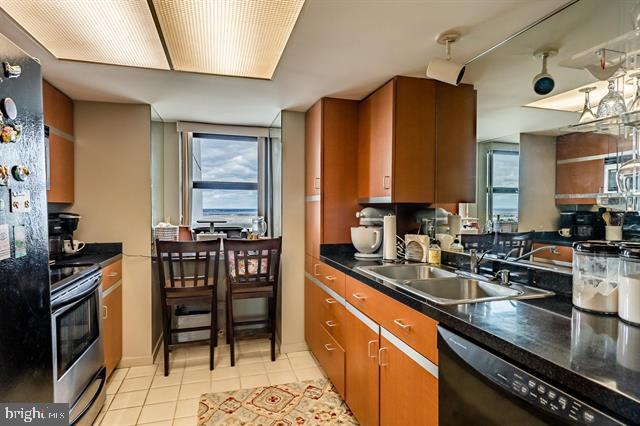 kitchen featuring light tile patterned floors, sink, and black appliances