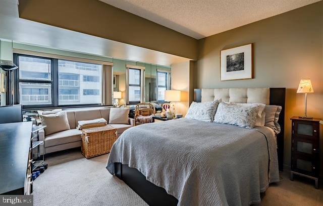 bedroom with light carpet and a textured ceiling