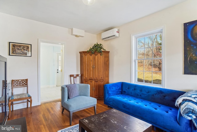 sitting room with an AC wall unit and dark wood-type flooring