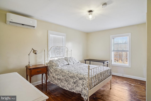 bedroom with dark wood-type flooring and a wall mounted AC