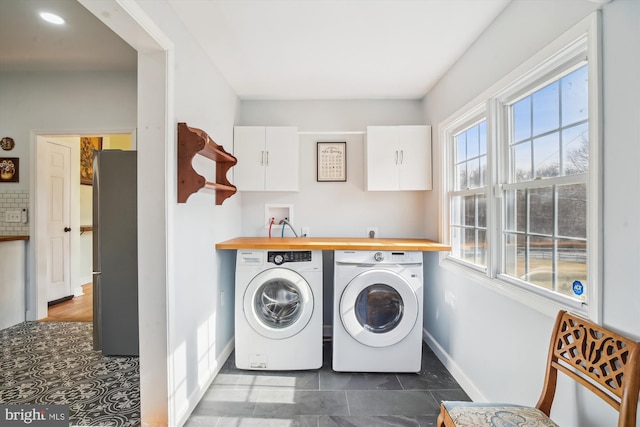 laundry room featuring cabinets and washer and dryer