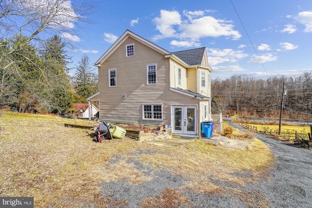 back of property with french doors and a yard