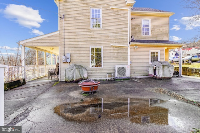 rear view of property featuring a patio area and ac unit