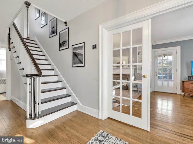 stairs with hardwood / wood-style flooring, french doors, and ornamental molding