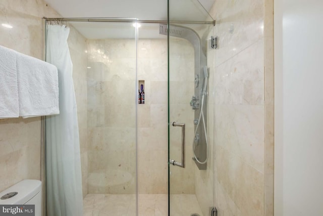 full bath featuring a stall shower and toilet