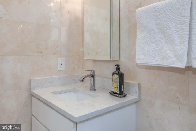 bathroom with backsplash, vanity, and tile walls