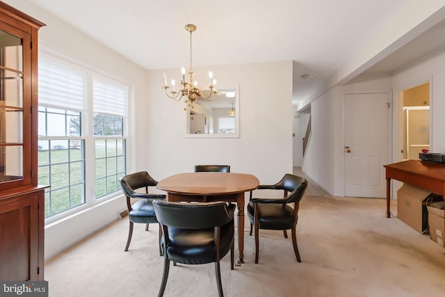 dining room with a chandelier and light colored carpet