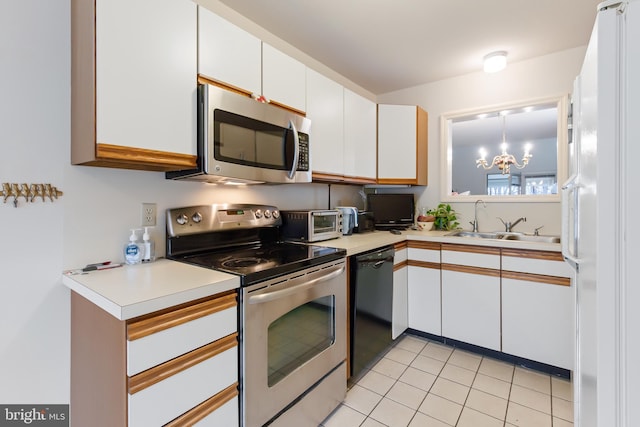 kitchen featuring light tile patterned floors, stainless steel appliances, light countertops, white cabinetry, and a sink