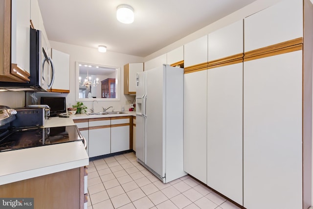 kitchen featuring light countertops, stainless steel microwave, white cabinets, a sink, and white fridge with ice dispenser