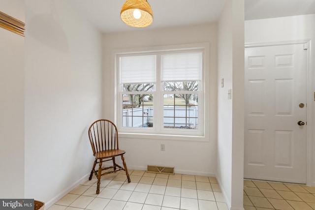 foyer entrance featuring light tile patterned floors, visible vents, and baseboards