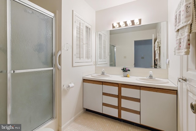 full bath featuring a shower with shower door, a sink, and double vanity