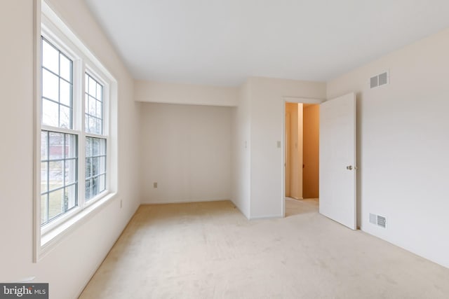 unfurnished bedroom with visible vents and light carpet