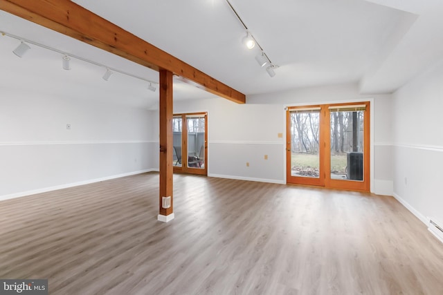 unfurnished living room with baseboards, light wood-style flooring, and track lighting