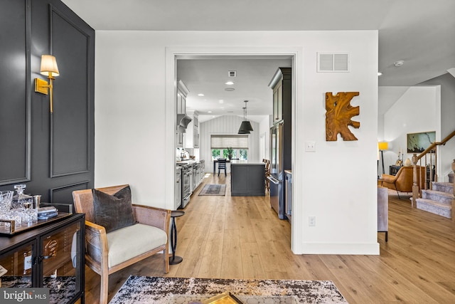 corridor with vaulted ceiling and light hardwood / wood-style floors