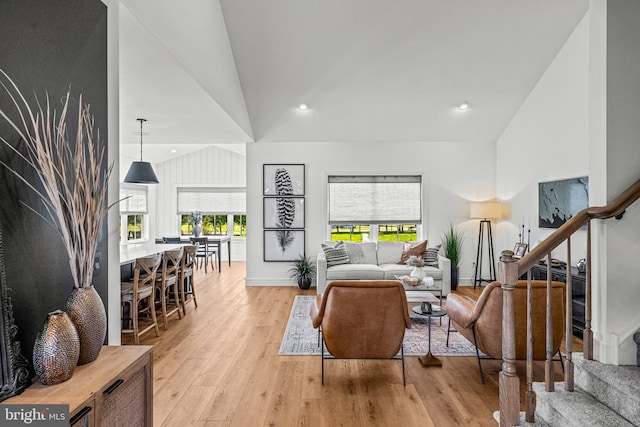 living room with high vaulted ceiling and light hardwood / wood-style floors