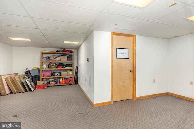 basement featuring carpet and a drop ceiling