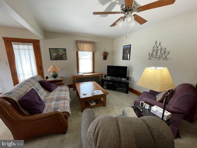 living room with radiator heating unit, light carpet, and ceiling fan