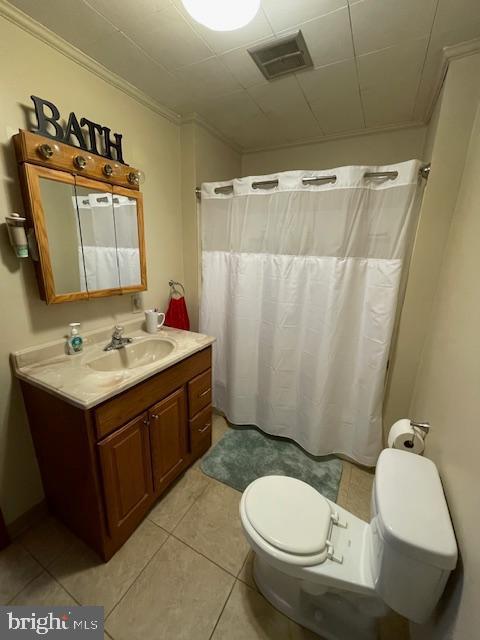 bathroom with tile patterned floors, curtained shower, ornamental molding, toilet, and vanity