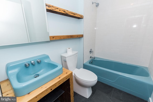 bathroom featuring shower / washtub combination, a sink, toilet, and tile patterned floors