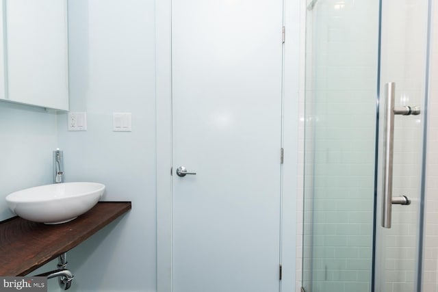 full bathroom featuring a stall shower and a sink