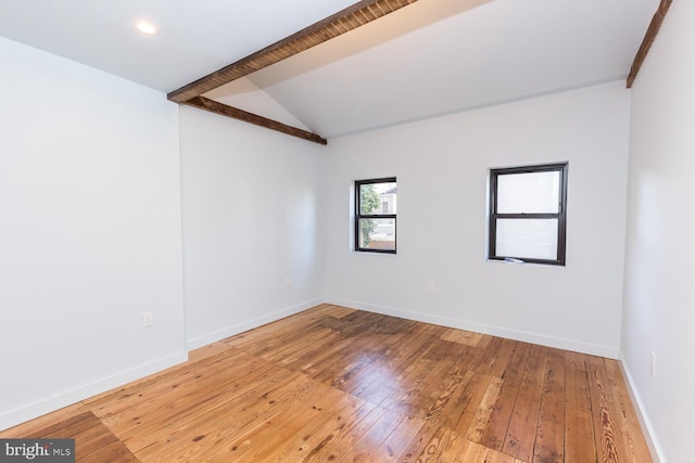 empty room with lofted ceiling with beams, baseboards, and wood finished floors