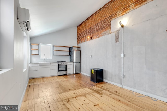 kitchen with a sink, white cabinetry, light countertops, appliances with stainless steel finishes, and light wood finished floors