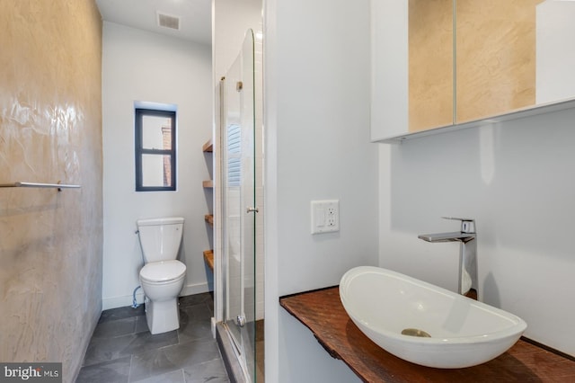 full bathroom featuring toilet, a sink, visible vents, tile patterned floors, and a stall shower