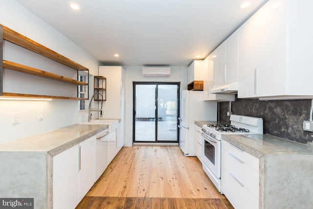 kitchen featuring white appliances, under cabinet range hood, white cabinets, and light countertops