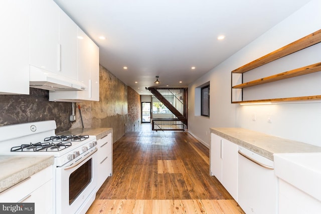 kitchen with light countertops, white cabinets, wood finished floors, white appliances, and under cabinet range hood