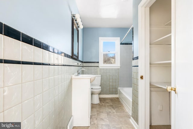 full bathroom with shower / bath combination, vanity, tile walls, and toilet